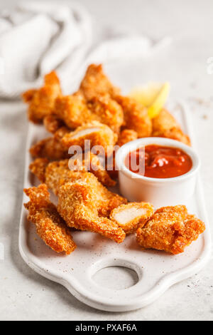 Fried chicken with tomato sauce on a white board. Stock Photo
