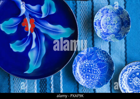 Blue and white plates on blue textured table cloth - top view photograph Stock Photo