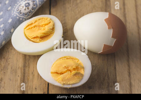 Boiled egg isolated on rustic wooden table - selective focus on hardboiled egg slice Stock Photo