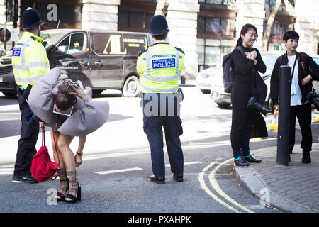 LONDON, UK- SEPTEMBER 14 2018: People on the street during the London Fashion Week. Asian woman with ponytail in checkered dress from Burberry and red Stock Photo