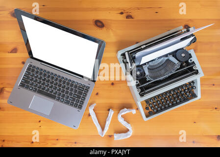 Old typewriter vs new laptop on the table. Concept of technology progress. Stock Photo