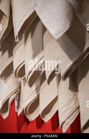 Soft towels drying on rack in bathroom Stock Photo