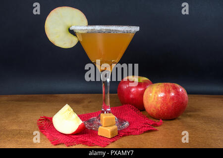 apple cider martini with caramel apples and ripe apples on wood table Stock Photo
