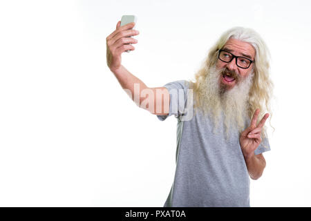Studio shot of happy senior bearded man smiling and giving peace Stock Photo
