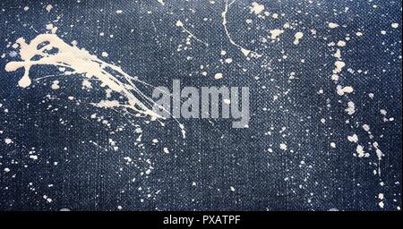 Texture of denim or blue jeans background. Abstract oil paint texture on canvas. Drops of colorful paint on blue background denim, jeans. Stock Photo
