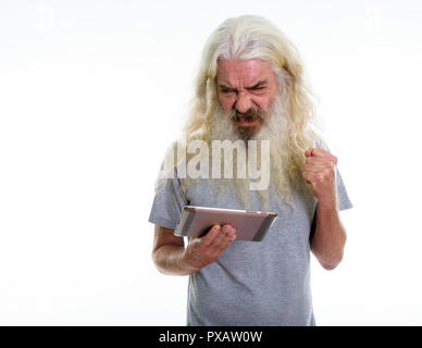 Studio shot of senior bearded man using digital tablet while loo Stock Photo