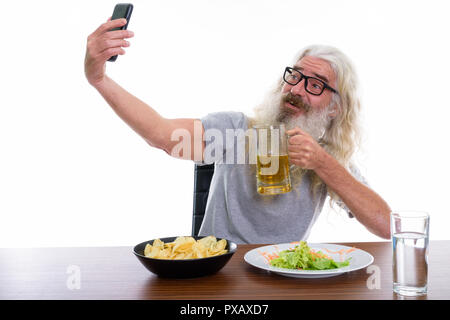 Happy senior bearded man smiling while taking selfie picture wit Stock Photo