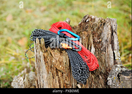 Metal carabine and rope for mountaineering. Photo of colored carabines and rope. Climbing concept Stock Photo