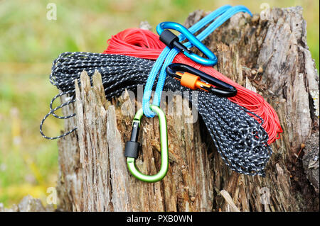 Metal carabine and rope for mountaineering. Photo of colored carabines and rope. Climbing concept Stock Photo