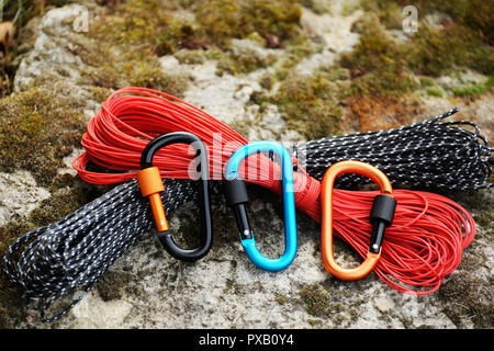 Metal carabine and rope for mountaineering. Photo of colored carabines and rope. Climbing concept Stock Photo