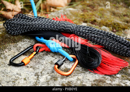 Metal carabine and rope for mountaineering. Photo of colored carabines and rope. Climbing concept Stock Photo