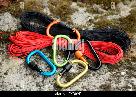 Metal carabine and rope for mountaineering. Photo of colored carabines and rope. Climbing concept Stock Photo