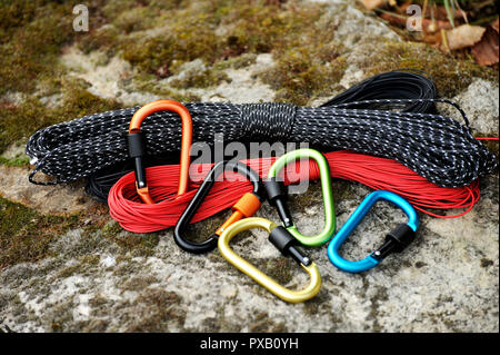 Metal carabine and rope for mountaineering. Photo of colored carabines and rope. Climbing concept Stock Photo