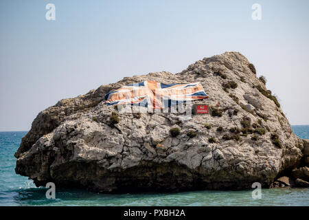 A large rock with the Union Jack in Catalan Bay on the East side of the Rock of Gibraltar. Gibraltar is a British Overseas Territory located on the so Stock Photo