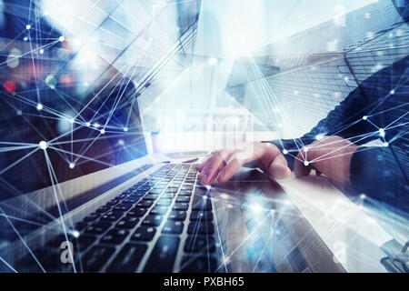 Business man works in office with laptop in the foreground. Concept of teamwork and partnership. double exposure with network effects Stock Photo