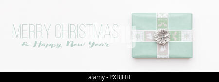Christmas banner. Beautiful christmas gift isolated on white background. Turquoise colored wrapped xmas box. Gift wrapping concept. Stock Photo