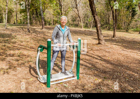 Elderly Woman In Sports Clothes Exercising At Outdoor Fitness Park, Healthy Lifestyle Mature People. Stock Photo