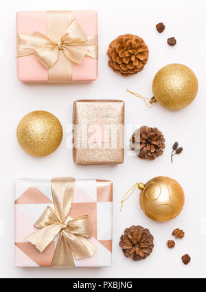 Pink and gold christmas gifts isolated on white background. Wrapped xmas boxes, christmas ornaments, baubles and pine cones. Christmas composition. Stock Photo