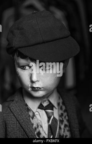A vintage mannequin of a boy in shirt and tie and wearing a schoolboy's cap. Stock Photo
