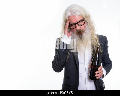 Studio shot of senior bearded businessman holding bottle of beer Stock Photo