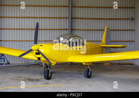 outdoor shot of small plane standing in shed Stock Photo