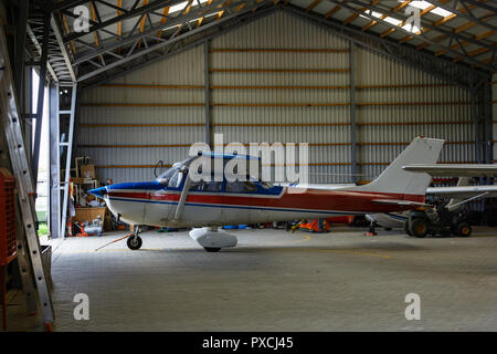 outdoor shot of small plane standing in shed Stock Photo