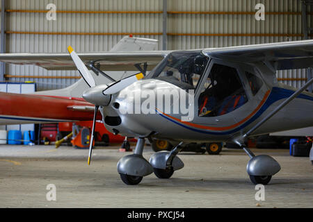 outdoor shot of small plane standing in shed Stock Photo