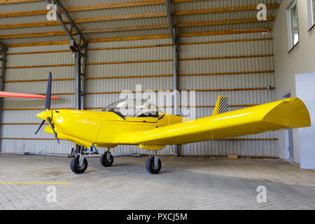 outdoor shot of small plane standing in shed Stock Photo