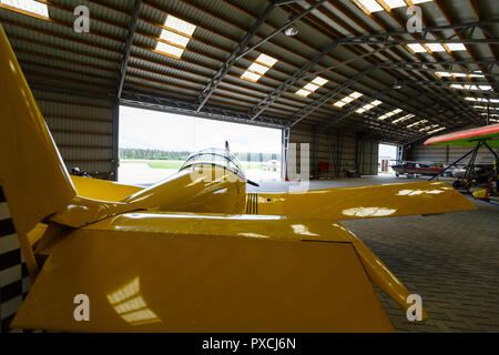 outdoor shot of small plane standing in shed Stock Photo