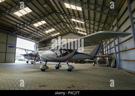 outdoor shot of small plane standing in shed Stock Photo