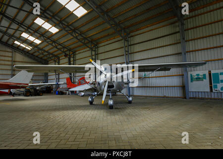 outdoor shot of small plane standing in shed Stock Photo