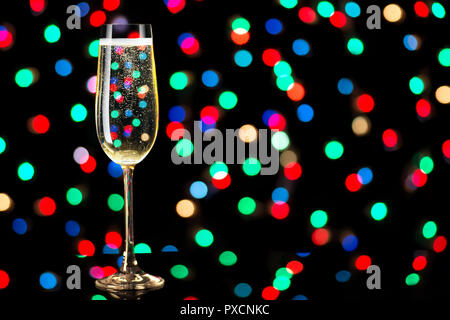 glass of champagne on black background with colored lights Stock Photo