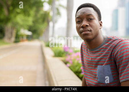 Young handsome African man relaxing at the park Stock Photo