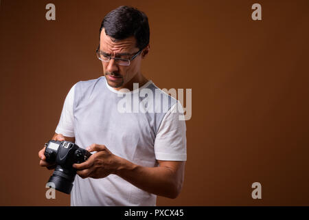 Portrait of photographer man against brown background Stock Photo