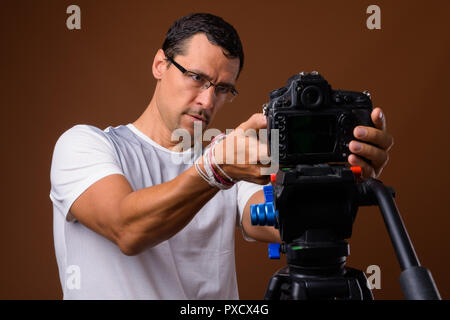 Portrait of photographer man looking camera on tripod Stock Photo