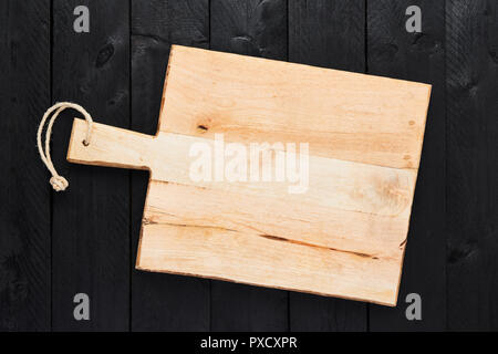 Top view of empty chopping board on black wooden table with copy space. Stock Photo