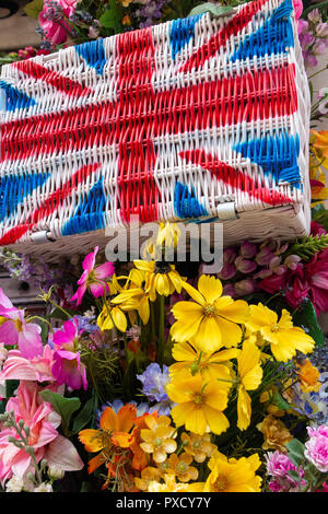 Union flag hampers amongst brightly coloured flowers in the summer Stock Photo