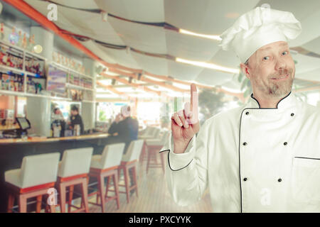 The chef is a white man in uniform with a bar counter. Stock Photo