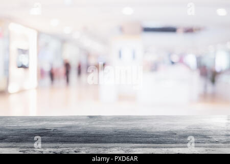 wood table with shopping mall store blurred background Stock Photo