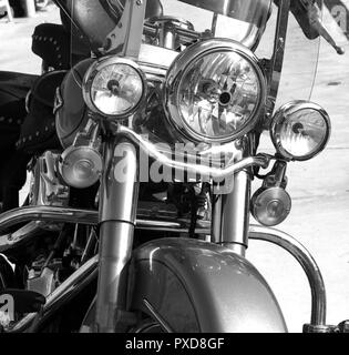 three headlights of a large classic motorbike with metal chrome, parked, black and white photo Stock Photo