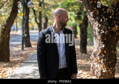 A handsome young businessman talking on his phone in the park Stock Photo