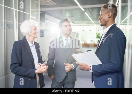 Content business colleagues communicating in office Stock Photo