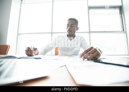 Busy African manager doing business analysis Stock Photo