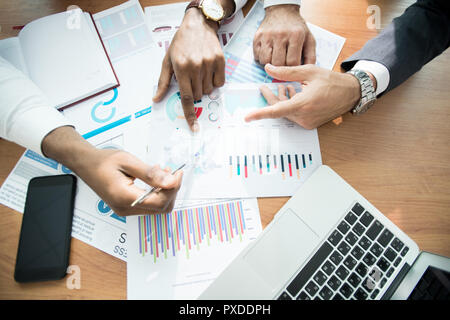 Business analysts discussing graphs at workplace Stock Photo