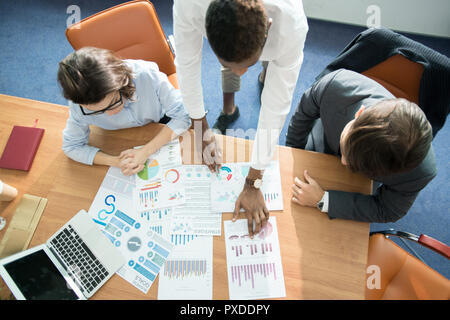 Marketing team analyzing statistics at meeting Stock Photo