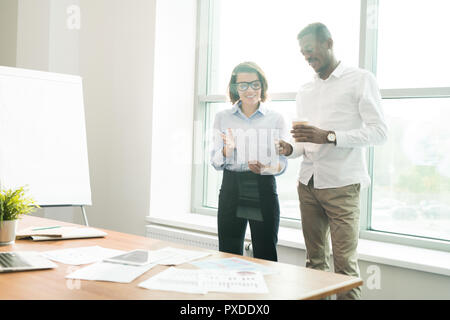 Confident analysts viewing data in board room Stock Photo