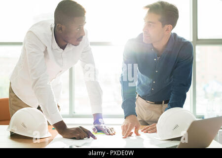 African construction engineer explaining building project to col Stock Photo