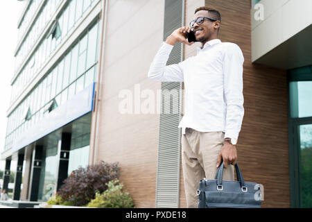 Smiling confident manager talking to client on phone Stock Photo