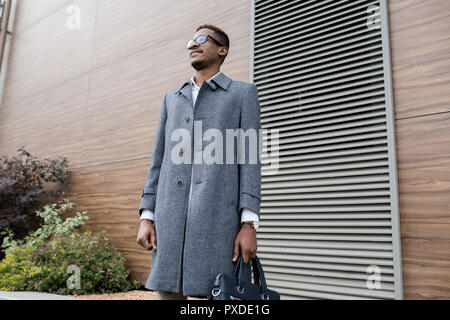 Pensive stylish African businessman with briefcase Stock Photo