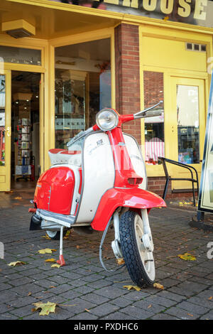 Red and white Lambretta motor scooter parked on pavement Stock Photo